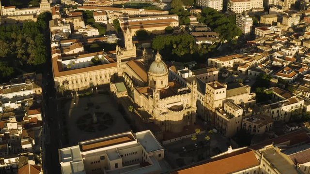 Cinematic flight early sunny morning over the Cattadrale Santa Vergine Maria Assunta, Palazzo dei Normanni, Cappella Palatina, in the historic part of Palermo. Sicily, Italy. May 2019. Aerial shot