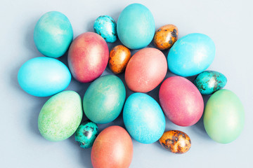 Fototapeta na wymiar Bright multi-colored Easter eggs on a blue background, top view. Easter background.