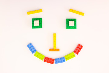 Smiley face made of colorful plastic bricks for kids
