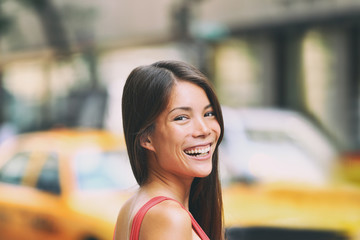 Happy Asian woman portrait smiling on New York city street NYC people lifestyle. Background of...