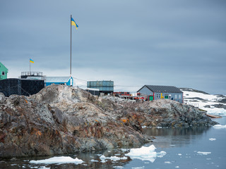 view to antarctic coast with building of ukrainian polar station and ukrainian flag in Antarctica © sergejson