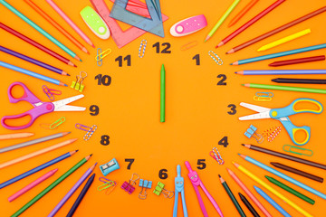 Creative clock made of school and office supplies with clock wise 