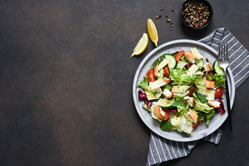 Caesar - salad with cheese, crackers and sauce. Green salad on a concrete background. View from above.