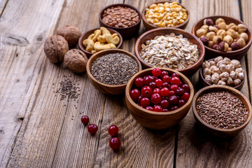 Different superfoods set, seeds, nuts,  grains, cranberries, oatmeal. Vegetarian healthy diet concept.