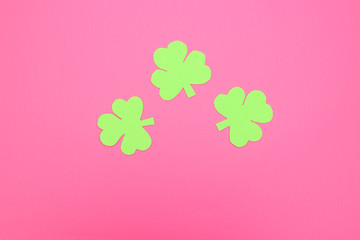 Green hand crafted clovers on colored background 
