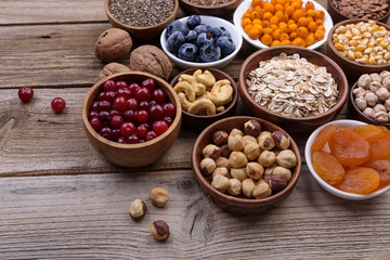 Different superfoods set, seeds, nuts,  grains, cranberries, dried apricots, sea buckthorn, blueberries, oatmeal. Vegetarian healthy diet concept.