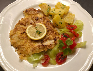 Escalope Parisian Style with parsley potatoes and lemon. Classic dish of French cuisine.