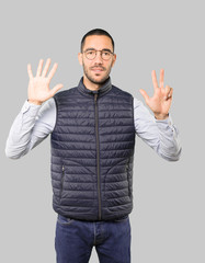 Fototapeta premium Happy young man doing a number eight gesture with his hands