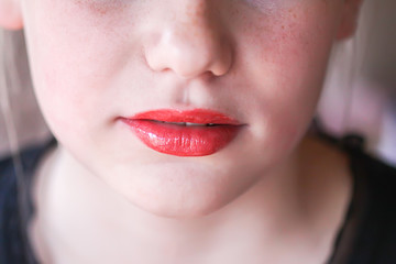 Naklejka premium Young attractive teenager girl's face view with lipstick on lips