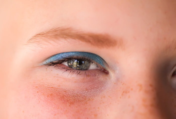 Young attractive teenager girl's face view with mascara and eye-shadow makeup.