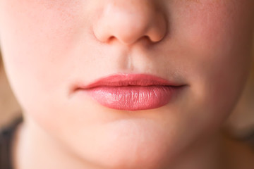 Young attractive teenager girl's face view with lipstick on lips