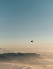 Image of some hot air balloons flying through the blue sky