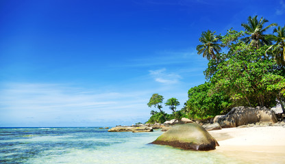 View at amazing tropical beach with beautiful white sand , crystal blue ocean and island at background. Space for text
