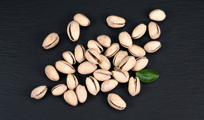 Handful of pistachios on a black background - healthy snack. Top view.