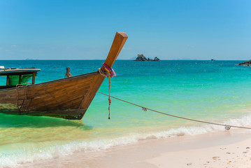 Traditional Thai longtail boat moored on exotic beach.