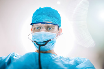 surgeon doctor in the operating room looking at the camera.