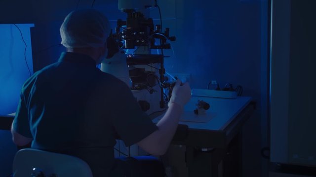 In a Modern Laboratory Scientist Conduct Experiments. The embryologist Examines Samples with a Microscope