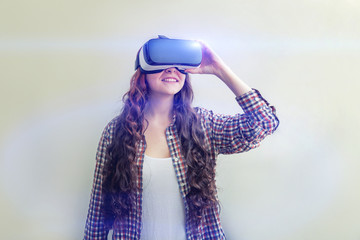 Smile young woman wearing using virtual reality VR glasses helmet headset on white background. Smartphone using with virtual reality goggles. Technology, simulation, hi-tech, videogame concept.