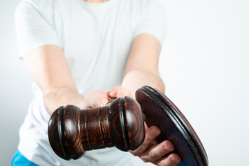 The man holds a wooden auction hammer in his hand. The concept of bidding and buying items. Buying...
