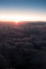 Sunset above the clouds. The view of the sunset from the plane. Rays of the sun through the clouds. Выделите текст, чтобы посмотреть примеры