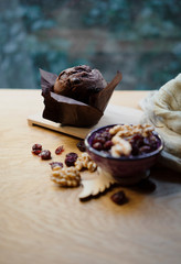 chocolate muffin, walnuts, berry on wood table