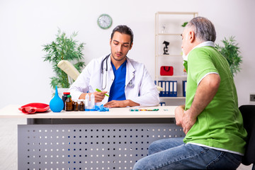 Old man visiting young male doctor gastroenterologist