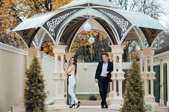 Couple posing in the gazebo. Young couple in love outdoor. Young stylish fashion couple posing.  - Powered by Adobe