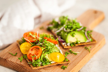 Avocado rye toasts with green herbs, onion and cherry tomatoes, healthy food