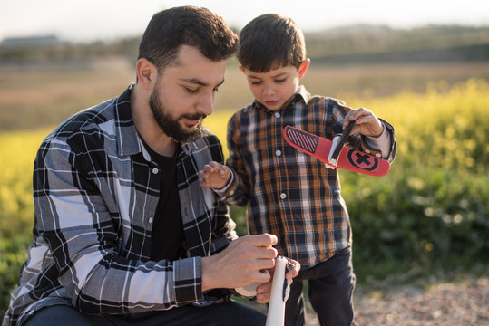 Father and son repairing airplane toy - Powered by Adobe