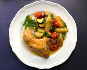 Golden crispy chicken leg with oven vegetables.