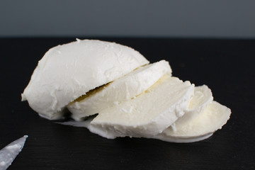 Large mozzarella with a blackened slate board.