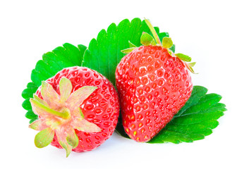 Two whole raw strawberries and leaves isolated on a white