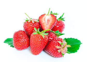 Heap of strawberries with half cut and leaves isolated on a white