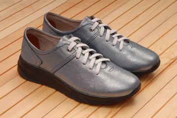 leather blue footwear, shine sneakers are on wooden background