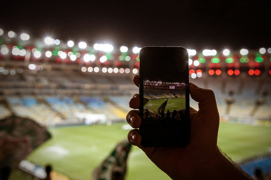 Smartphone photographing football game on the stadium
