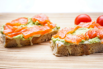 Sandwich with avocado and smoked salmon, close-up.