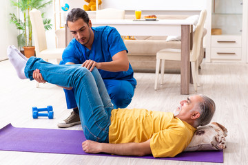 Young male doctor visiting old patient at home