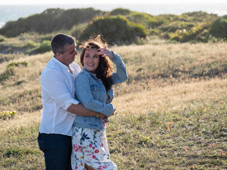 Hombre joven abraza a su novia mientras la mira en el campo al atardecer