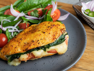 Baked chicken fillet stuffed with spinach, tomatoes and cheese