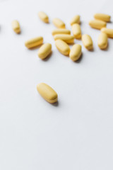 Scatterded yellow pills on white background 