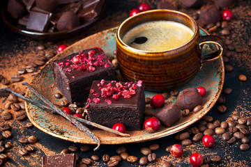 Chocolate brownie cakes dessert with cranberry and  coffee mug on  dark background