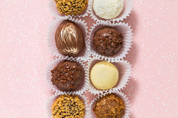 Truffle and coconut chocolates on a shiny background top view