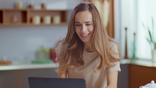 Businesswoman receiving good news on laptop. Freelancer working at home