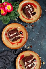 Chocolate cake with cream on dark background. Top view with copy space.