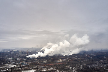 Aerial view of factory pipes throwing hazardous emissions into the air.
