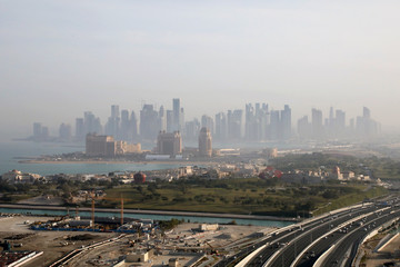 Naklejka na ściany i meble Doha / Qatar – February 17, 2020: The towers of the West Bay area of Doha, shrouded in mist, with the Lusail Expressway in the foreground