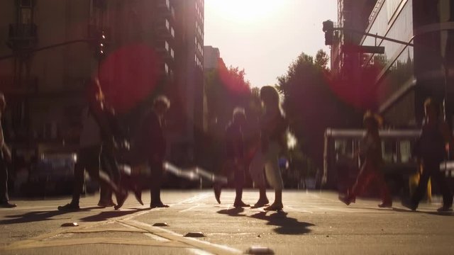City Crowd pedestrians crossing crosswalk avenue at sunset. Silhouette, commercial shot.