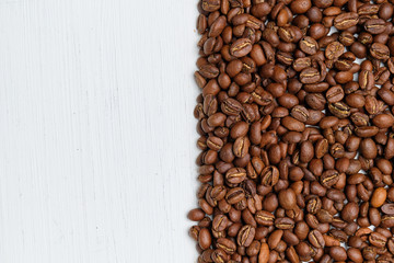 Roasted coffee beans on a wooden background with copy space.