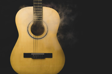 Acoustic guitar in smoke close up. musical instrument. strings on the guitar neck