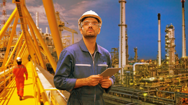 Caucasian Man Engineer Staff Worker With Tablet In Hand And Refinery Background Concept.